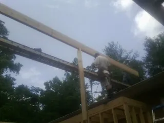 Carpenter setting a ridge beam over a new addition frame — Ice Dam Removal by Roofing Brothers in Coeur d'Alene