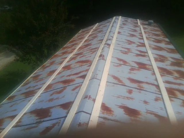 Rusted metal roof panels with new wood purlins before replacement — Storm Damage Roof Repair in Coeur d'Alene by Roofing Brothers