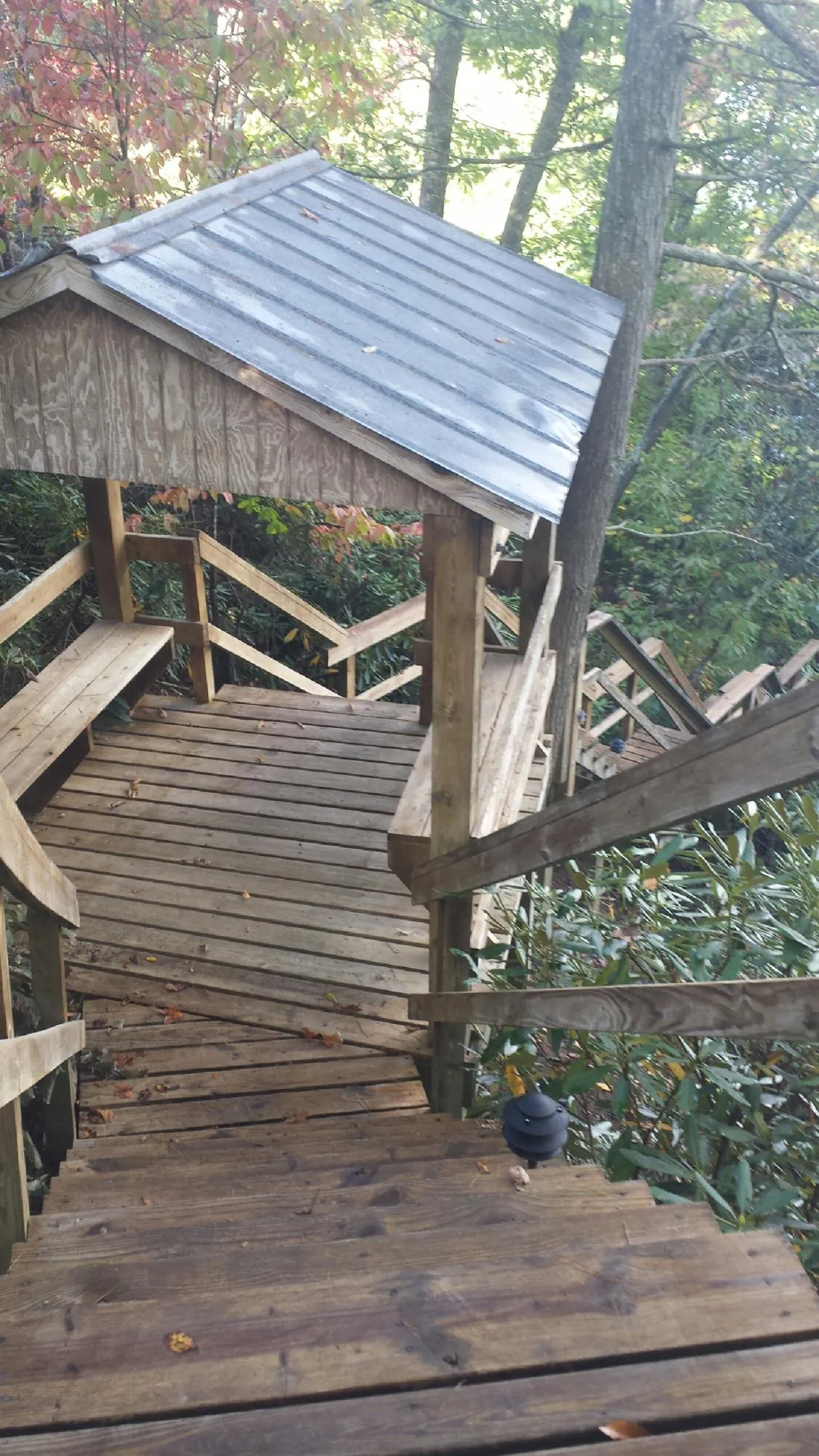 Metal roofed shelter over wooden steps on a wooded walkway — Skylight Repair & Installation work by our crew in Coeur d'Alene